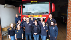 Gruppenbild Feuerwehrleute vor Einsatzwagen