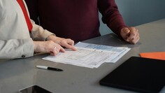 Zwei Menschen beschäftigen sich mit Formularen