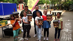 Foto: Kinder halten selbstgebaute Insektenhotels in den Händen
