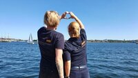 Zwei Frauen senden dem Meer ein Herz