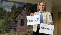 Frau hält Blatt mit Aufschrift "Danke" in die Kamera
