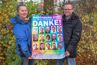 Foto: Zwei Personen halten ein Plakat