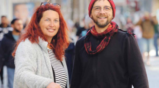 Zwei Menschen lächeln in die Kamera